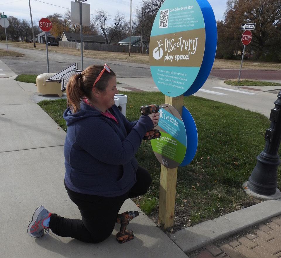 Installing sign at the new outdoor discovery play space